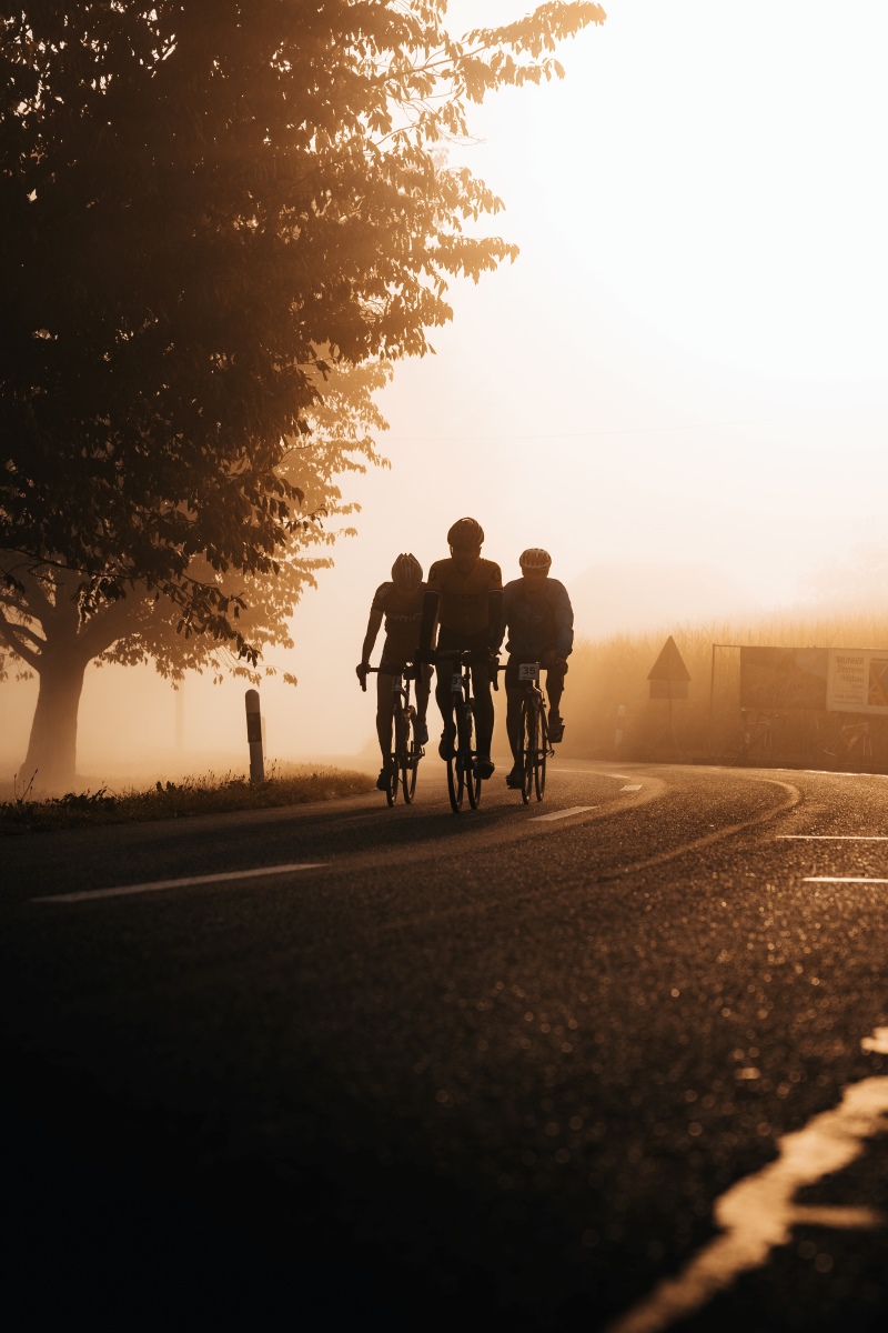 Gruppe von drei Fahrradfahrern im stimmungsvollen Morgenlicht